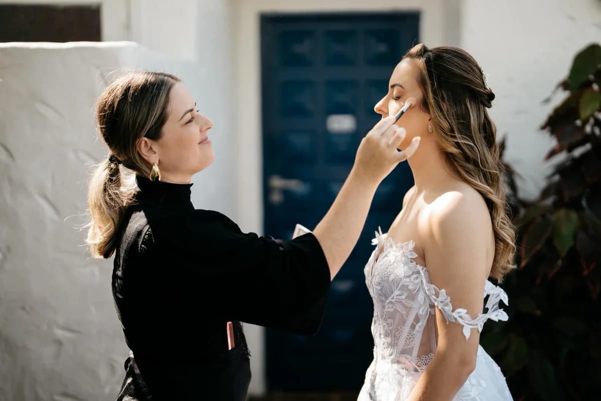 Karol Carminatti maquiando noiva nos bastidores do casamento em Florianópolis